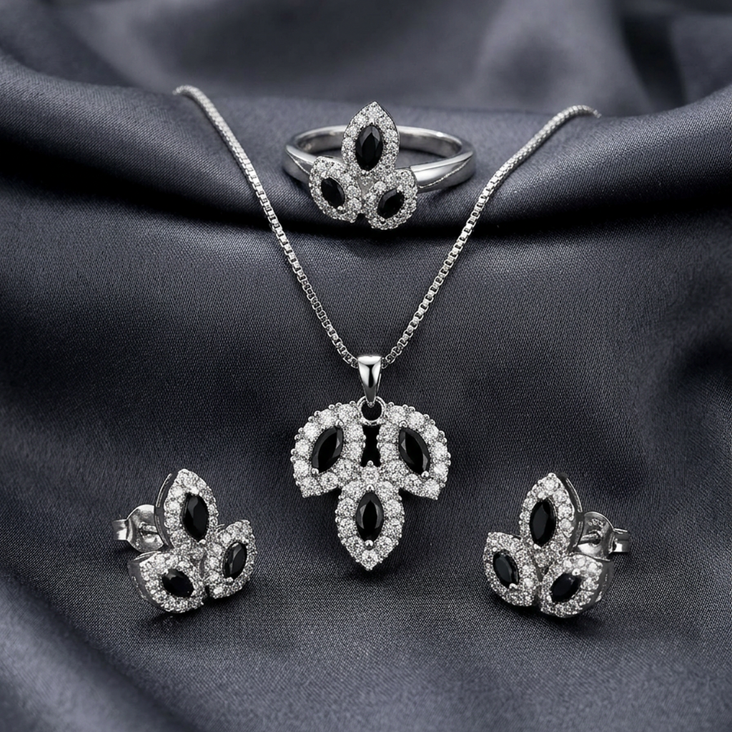 Silver leaf stone jewelry set by Zaraya Store with black marquise-cut and clear pavé stones, including necklace, ring, and earrings on dark fabric.