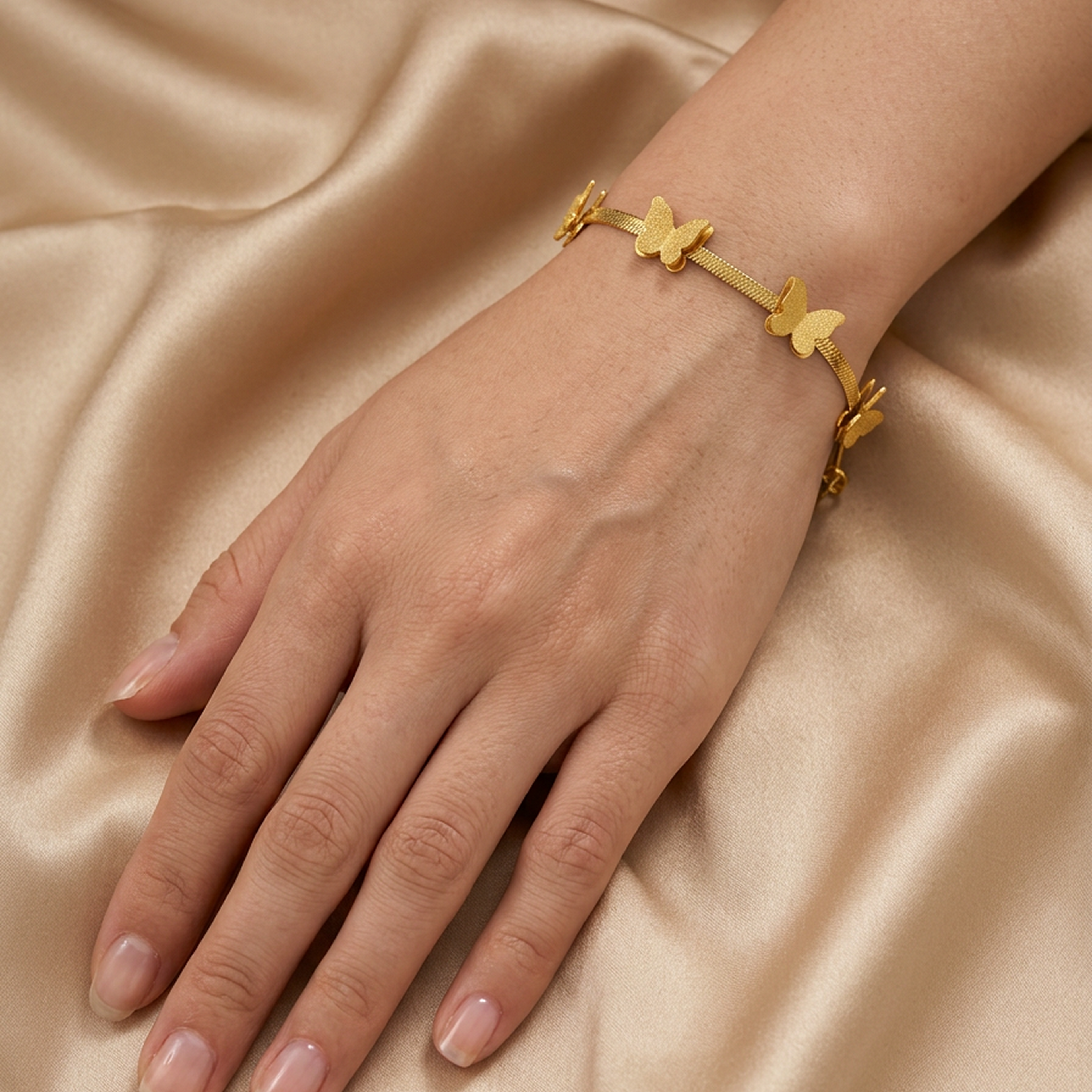 Gold-plated bracelet by Zaraya Store featuring multiple textured butterfly charms on a woman's wrist against golden fabric.