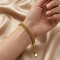 Gold braided mesh bracelet by Zaraya Store, worn on a wrist with an adjustable chain and 'M' initial charm on champagne satin.
