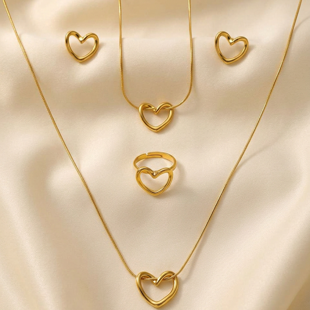 4-piece gold stainless steel heart jewelry set by Zaraya Store, featuring two necklaces, a ring, and two earrings on cream fabric.