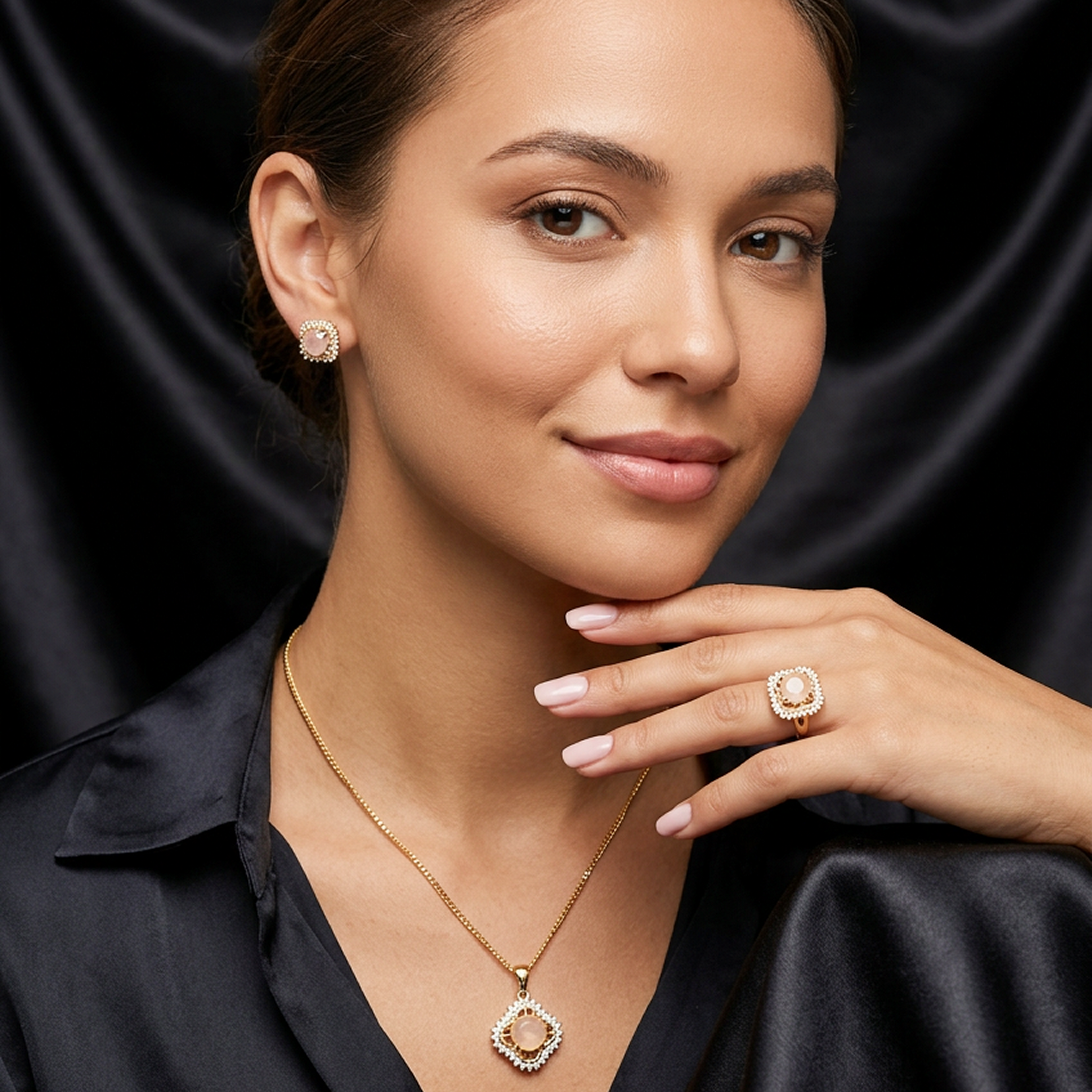 Light peach round stone and gold jewelry set featuring square halo designs, worn by a woman in a black satin top.