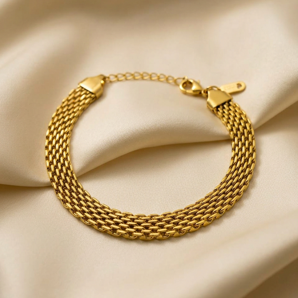 Gold braided mesh bracelet by Zaraya Store, with a clasp and extender, resting on a beige satin fabric.