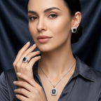 Silver jewelry set with square black stones and white halos worn by a woman in a dark gray collared shirt.