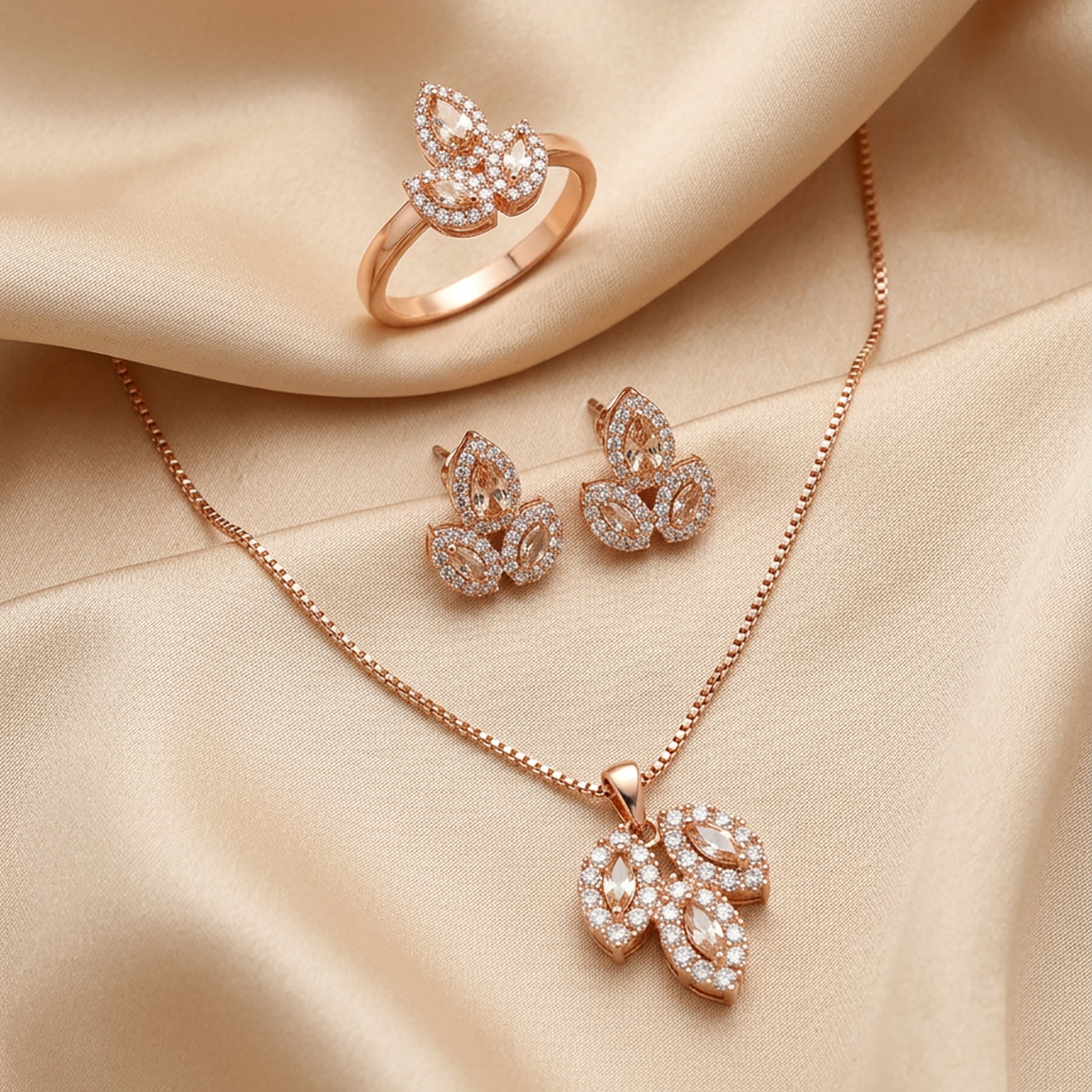 Luxury rose gold leaf stone jewelry set by Zaraya Store, with a ring, earrings, and necklace, on draped beige fabric.